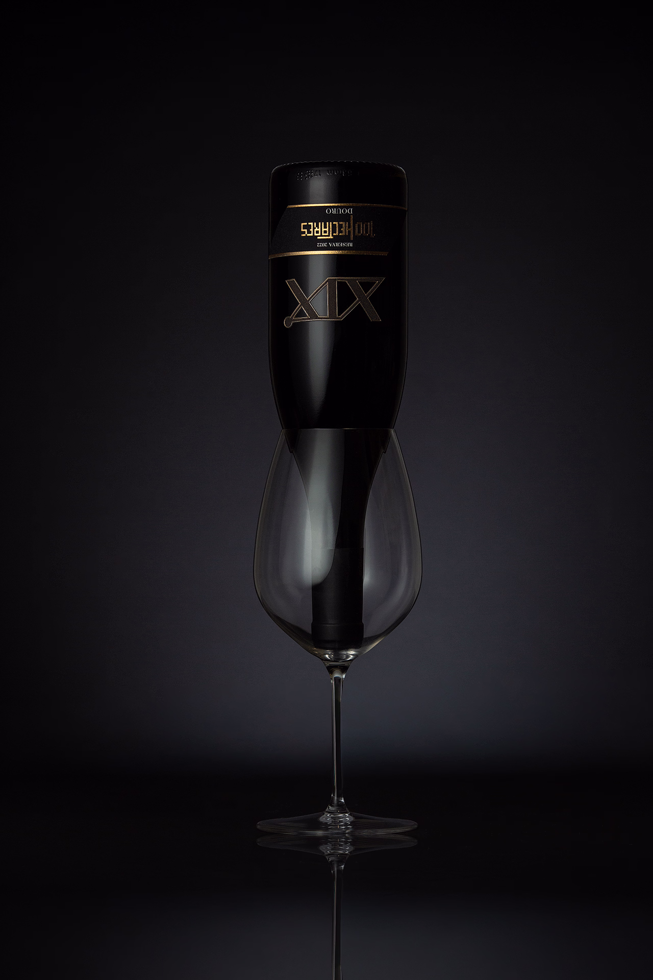 Fotografia profissional do vinho XIX Reserva 2022 100Hectares do Douro destacando garrafa premium com iluminação de estúdio e composição elegante fotografia de vinho Douro fotografia de produto vinho fotografia profissional vinhos vinho Douro Reserva fotografia comercial vinho fotografia garrafa vinho premium